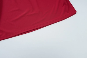 Detail shot of a red knitted dress hem featuring high-quality double-needle stitching