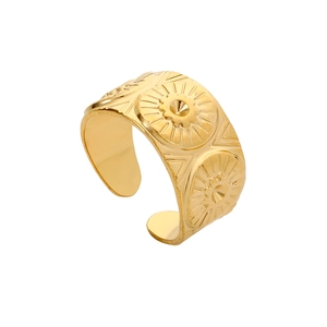 Détail de la bague en acier doré avec gravures solaires et motifs géométriques