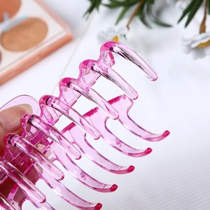 Detailed close-up of large pink translucent hollow hair claw clip with smooth glossy finish