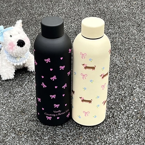 Détail de deux bouteilles isothermes en acier inoxydable en noir mat et couleur crème