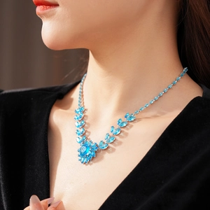 Detail of luxury necklace with blue gems and silver floral patterns on a model