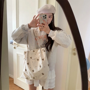Corduroy tote bag with brown bear and heart print shown in a casual mirror selfie style
