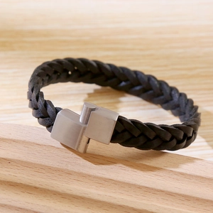 Macro detail of hand-woven black leather bracelet with secure silver magnetic clasp