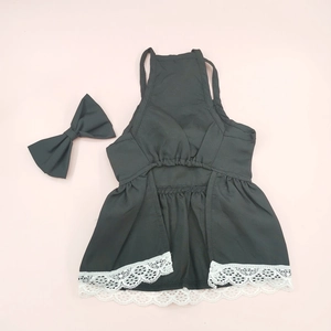 Flat lay of a black pet dress with white lace trim and matching bow tie accessory