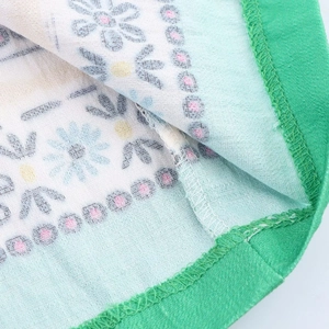 Macro de tissu tricoté à motif marguerites avec bordure verte et texture maille