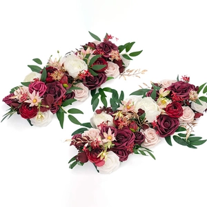 Close-up of artificial burgundy and pink floral swag with roses and green leaves
