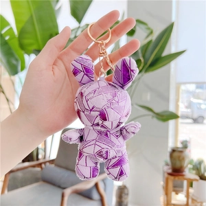 Detail view of purple plush bunny keychain with geometric patterns and golden metal ring