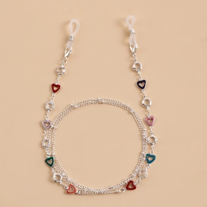 Detail of silver glasses chain featuring colorful enamel heart charms and silicone loops