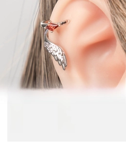 Detail shot of silver wing ear cuff with red rhombic zircon and copper material specs