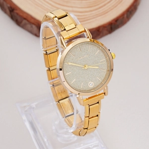 Detail of gold women watch with glitter dial and date window on acrylic stand