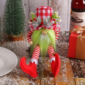 Christmas gnome doll with red plaid hat and green beard on snowy wood festive background