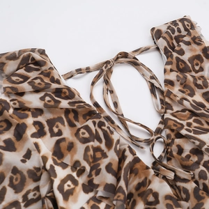 Close-up of leopard print mini dress featuring ruffle details and tie-up neck design