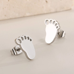 Close-up of baby footprint stud earrings in polished silver stainless steel finish
