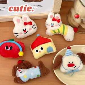 Detail shot of cute plush cartoon character hair clips on a natural wooden surface