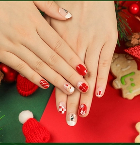 Close-up of short oval Christmas press-on nails with Santa Claus and snowflake art