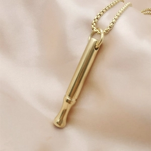 Detail shot of a polished gold meditation breathing necklace for stress and anxiety relief