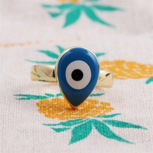 Vue détaillée de la bague goutte œil grec doré avec émail bleu sur tissu blanc