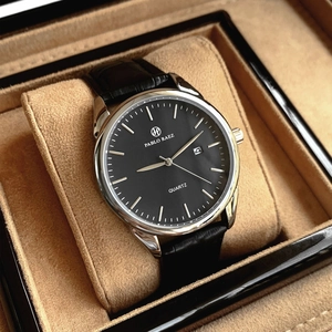 Macro view of men's quartz watch with black leather strap in luxury display box