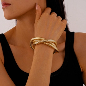 Close-up of golden spiral wrap bracelet with ribbed texture on a female wrist