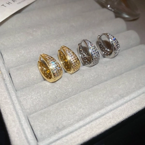 Macro shot of micro-pave zircon U-shape earrings in gold and silver plating