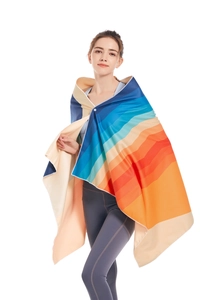 Rainbow striped microfiber beach towel worn as a cloak showing its large size and drape