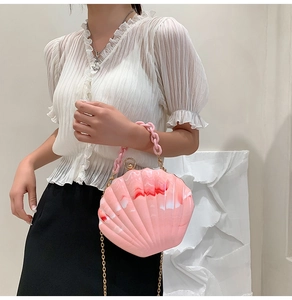 Pink marble shell acrylic bag detail showing resin texture and pink thick chain link strap
