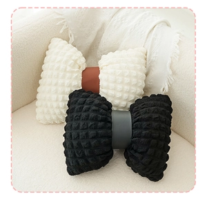 Detail view of bow-shaped pillows in cream and black with seersucker textured fabric