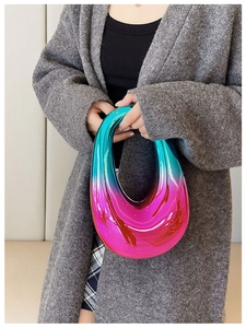 Model holding a rounded acrylic handbag with colorful iridescent gradient finish