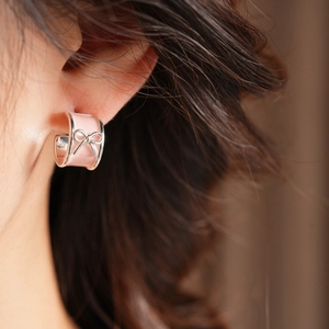 Close-up of pink enamel bow C-shaped stud earring with silver metal trim for women