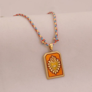 Gros plan du collier en cordon tressé avec pendentif tarot en émail cœur et œil