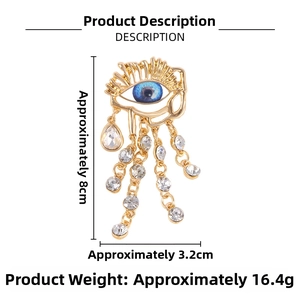 Detail of blue evil eye brooch with rhinestone fringe and gold-plated alloy finish