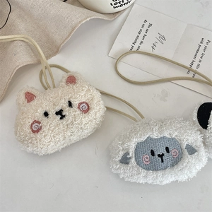 Dettaglio del portamonete in peluche sherpa morbido con ricami animali rifiniti