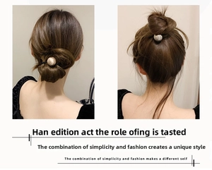 Close-up of minimalist hair ties with gold and pearl spheres for elegant hairstyles