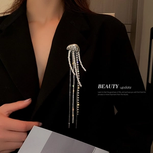 Elegant jellyfish brooch with pearl tassels and rhinestones on a dark blazer