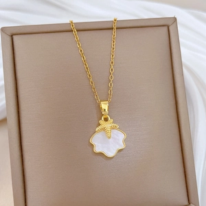 Dettaglio della collana dorata con ciondolo a conchiglia e stella marina su cofanetto