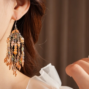 Detail of vintage bohemian tassel earrings with colorful beads on a gold base