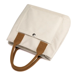 Canvas tote bag for women, stylish casual handbag with front pocket and durable handles.