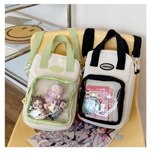 Detail of canvas ita bag showing transparent PVC window with pins and doll accessories
