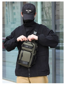 Detail of army green tactical sling bag with multi-zipper compartments and adjustable strap