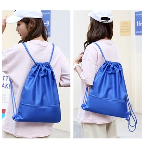 Detail view of blue oxford drawstring backpack featuring diamond texture and zipper pocket