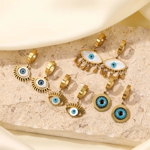 Three pairs of golden stainless steel evil eye earrings with cat eye stones on stone