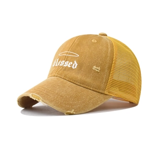 Detail of yellow mesh truck hat with blessed embroidery and distressed brim details