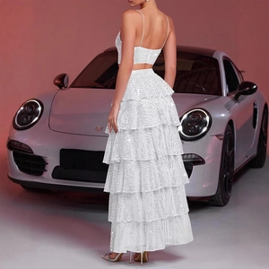 Detail of white sequin backless crop top and tiered maxi skirt set against a silver car