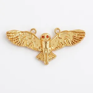 Detailed macro view of gold owl pendant with red zircon eyes and 29mm width dimensions