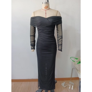 Détail de la robe longue noire à épaules dénudées avec manches en tulle et plis drapés