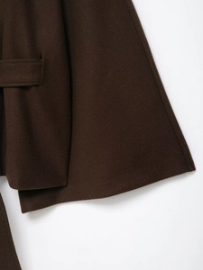Detailed close-up of dark brown wool coat fabric texture and side waist loop design