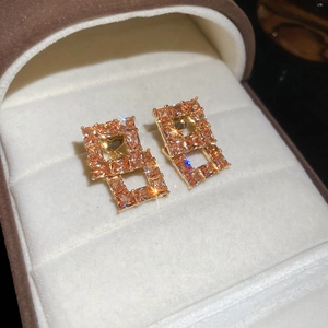 Detailed close-up of 18K gold plated hollow square stud earrings with zircon crystals