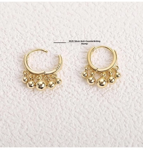 Detail view of gold-plated S925 sterling silver drop earrings with metallic bead tassels