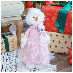 Dettaglio di un pupazzo di neve natalizio in maglia rosa con pelliccia e naso a carota