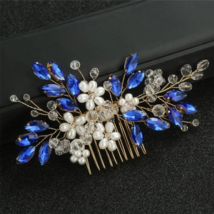 Detailed shot of bridal hair comb with blue leaf crystals and white pearl flowers